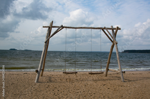 Big swing on the beach on the shore on a cloudy day