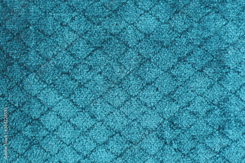Blue carpet with a diamond pattern. Scuff marks on the new carpet.

