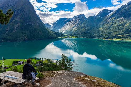 Urlaub in Süd-Norwegen: Junger Mann betrachtet die Aussicht: der schöne klare Berg-See Oppstrynsvatnet / Aussicht von Segestad photo