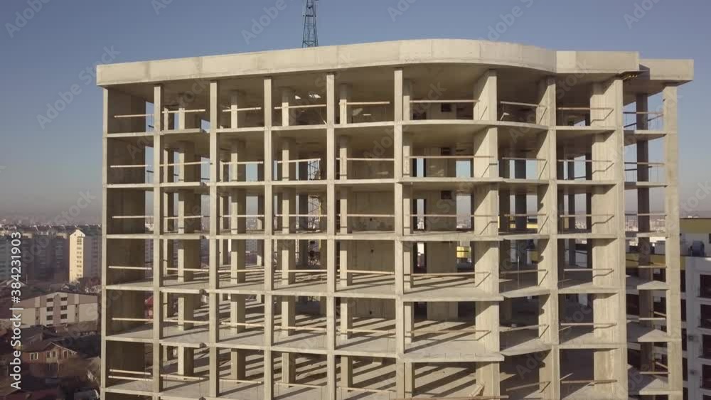 Aerial view of concrete frame of tall apartment building under construction in a city.
Aerial view of concrete frame of tall apartment building under construction in a city.