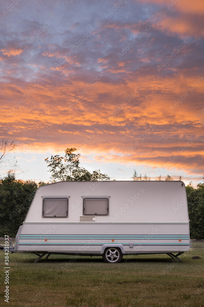 White Retro Caravan Parked in a Campsite. Mobile Home and Freedom at sunset