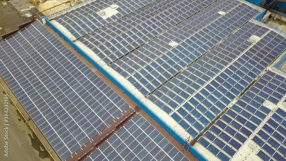 Aerial view of solar power plant with blue photovoltaic panels mounted of industrial building roof. Aerial view of solar power plant with blue photovoltaic panels mounted of industrial building roof.