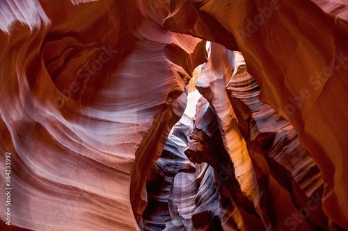 A view of the path through upper antelope canyon in northern arizona. This famous slot canyon is filled with light pockets and banded canyon walls.