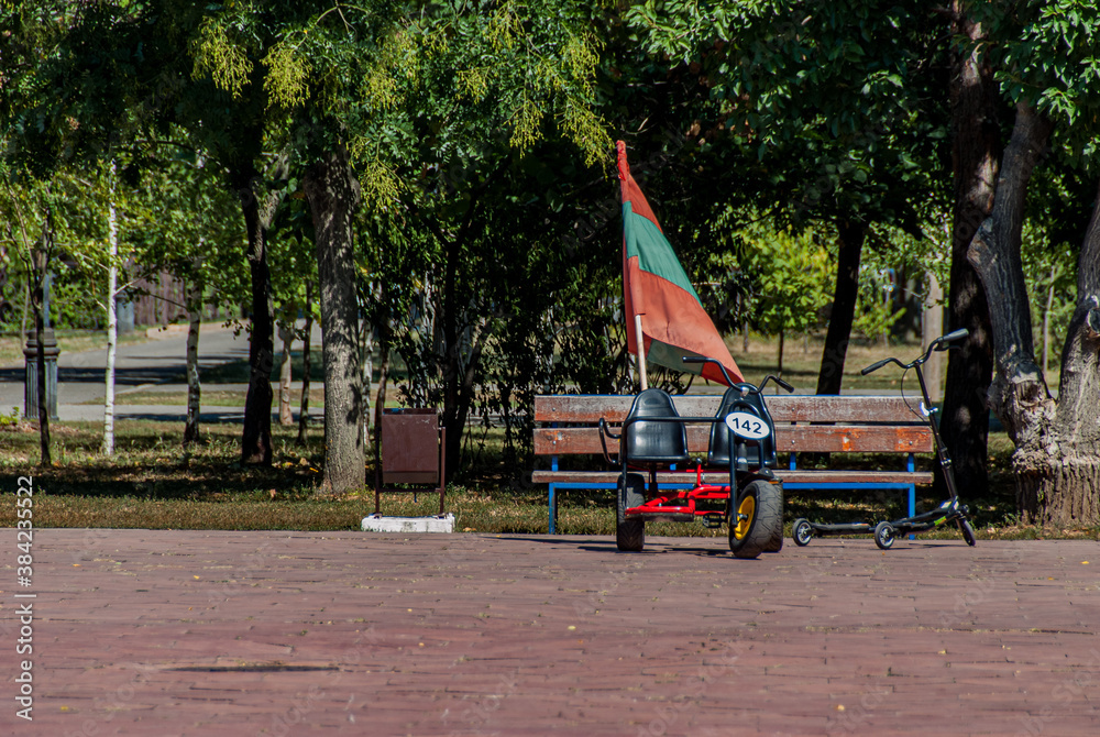 Obraz na płótnie Tiraspol, Transdniester, 1 September 2017. Flag of Transdniester attached to a pedal car in a public park. w salonie