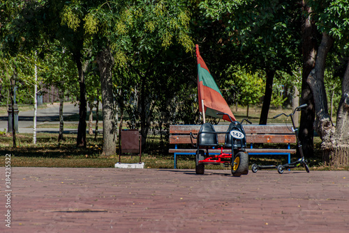 Tiraspol, Transdniester, 1 September 2017. Flag of Transdniester attached to a pedal car in a public park.