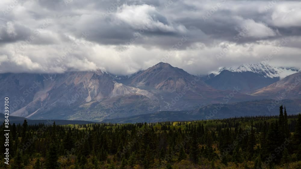 Canadian Rocky Mountain Landscape during a cloudy and sunny day in Fall Season. View from Alaska Highway in Yukon, Canada. Time Lapse Canadian Rocky Mountain Landscape during a cloudy and sunny day in Fall Season. View from Alaska Highway in Yukon, Canada. Time Lapse