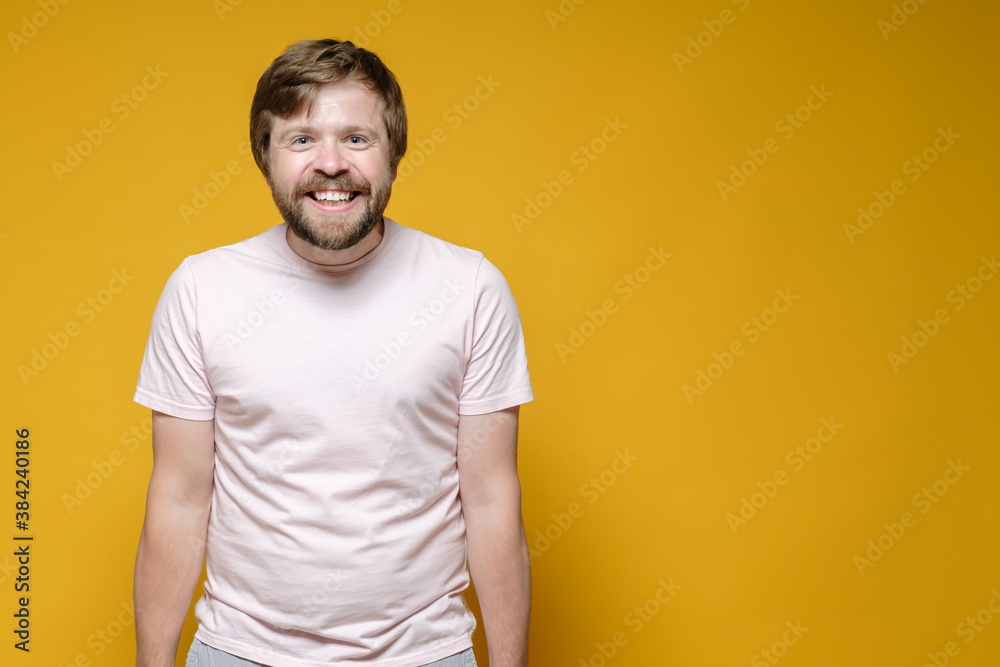 Positive, joyful man smiles broadly and looks into the camera. Copy space. Yellow background. Positive, joyful man smiles broadly and looks into the camera. Copy space. Yellow background.