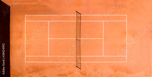 View from above, aerial view of an empty clay court. A clay court is a tennis court that has a playing surface made of crushed stone, brick, shale, or other unbound mineral aggregate. © Travel Wild