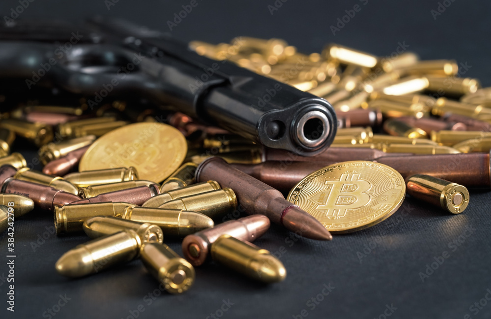 Bronze and brass gun bullets scattered on dark table, black pistol barrel, golden bitcoin coins near - illegal use of cryptocurrency to purchase weapon concept Bronze and brass gun bullets scattered on dark table, black pistol barrel, golden bitcoin coins near - illegal use of cryptocurrency to purchase weapon concept