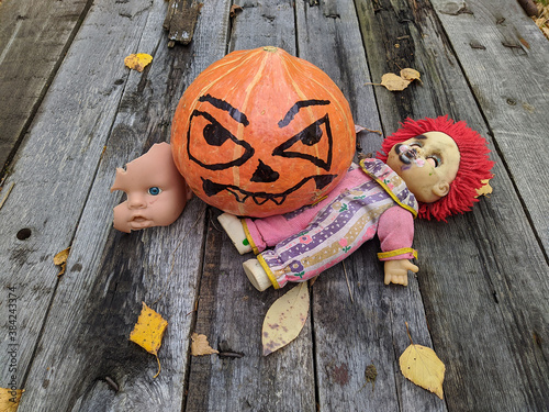 halloween pumpkin together with a gang of scary toys on an old wooden background together with autumn leaves photo