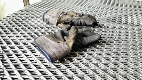 Work gloves on top of expanded sheet metal.
