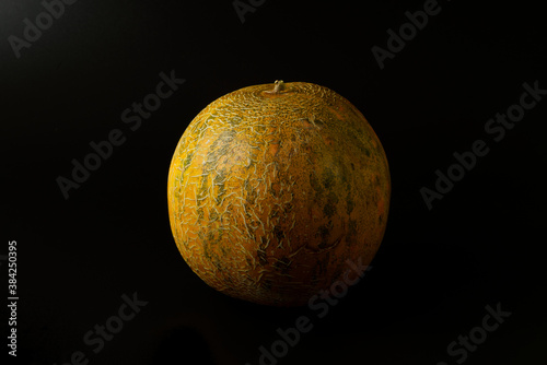 Ripe yellow melon isolated on a black background