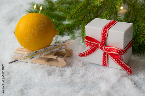 Medical bath, gift box, thermometer and Christmas tree on a snowy background. Copyspace. Medication. Catarrhal disease. Limon. new year. Christmas photo