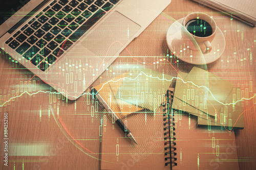 Stock market graph and top view computer on the table background. Double exposure. Concept of financial education.