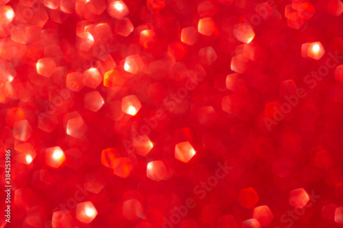 Red shiny blurred background with bokeh lights. Abstract festive background. Christmas, Valentine day concept.