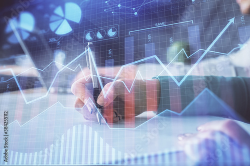 Double exposure of forex chart drawing over people taking notes background. Concept of financial analysis