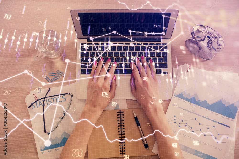 Double exposure of woman hands working on computer and forex graph hologram drawing. Top View. Financial analysis concept. Double exposure of woman hands working on computer and forex graph hologram drawing. Top View. Financial analysis concept.
