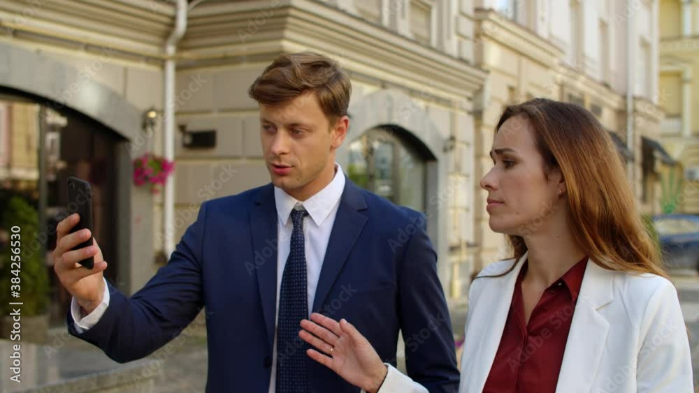 Serious business couple talking by video call online on mobile phone outdoors Serious business couple talking by video call online on mobile phone outdoors