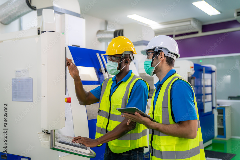 Asian industrial engineers and worker in hard hats discuss product line while using digital tablet in cnc milling cutting machine in a heavy industry manufacturing factory. Asian industrial engineers and worker in hard hats discuss product line while using digital tablet in cnc milling cutting machine in a heavy industry manufacturing factory.