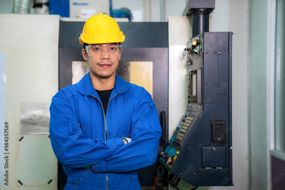 Asian engineer man wearing uniform safety workers arm crossed and perform maintenance in factory working CNC machine lathe metal, industry work man concept.. Asian engineer man wearing uniform safety workers arm crossed and perform maintenance in factory working CNC machine lathe metal, industry work man concept..
