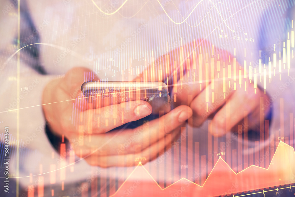 Multi exposure of man's hands holding and using a digital phone and forex graph drawing. Financial market concept. Multi exposure of man's hands holding and using a digital phone and forex graph drawing. Financial market concept.