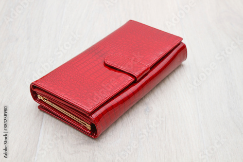closed red women's wallet on a gray background