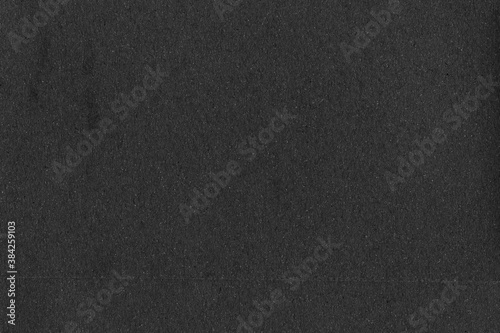 A black vintage rough sheet of carton. Recycled environmentally friendly cardboard paper texture. Simple gray minimalist papercraft background.