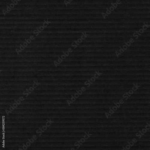 A black vintage rough sheet of carton. Recycled environmentally friendly cardboard paper texture. Simple gray minimalist papercraft background.