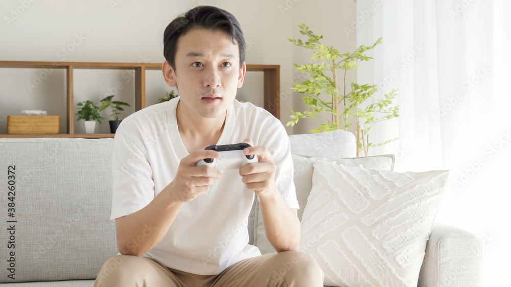 リビングでテレビゲームをする男性 リビングでテレビゲームをする男性
