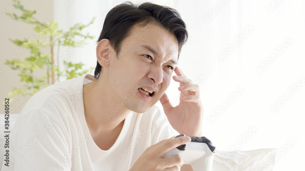 リビングでテレビゲームをする男性 リビングでテレビゲームをする男性