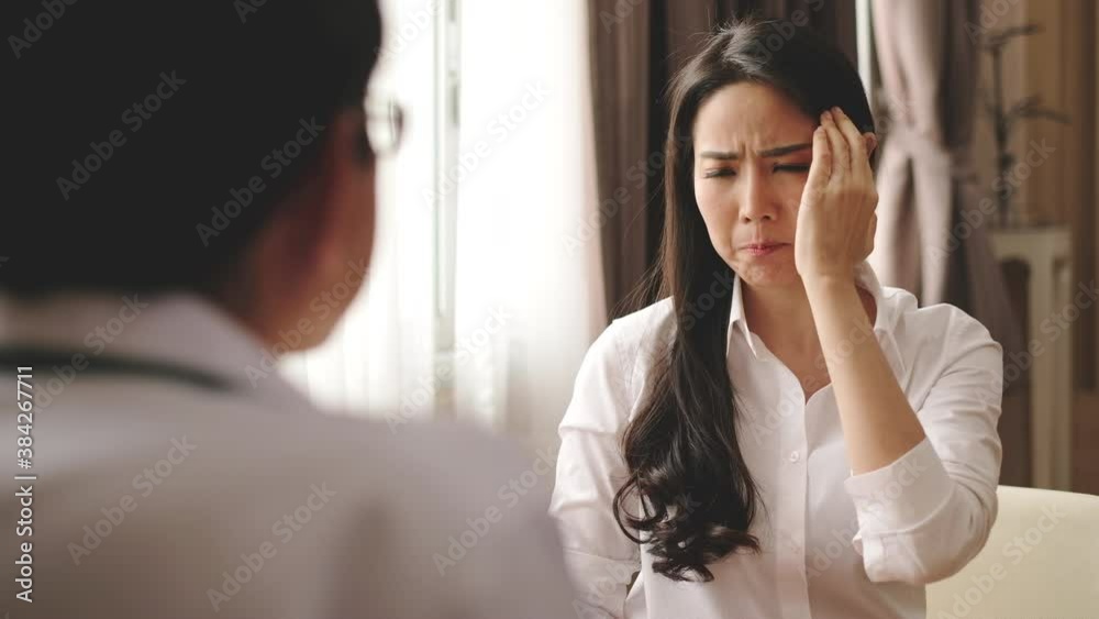 Asian woman patient talking with doctor about her illness of migraine headache in hospital Asian woman patient talking with doctor about her illness of migraine headache in hospital