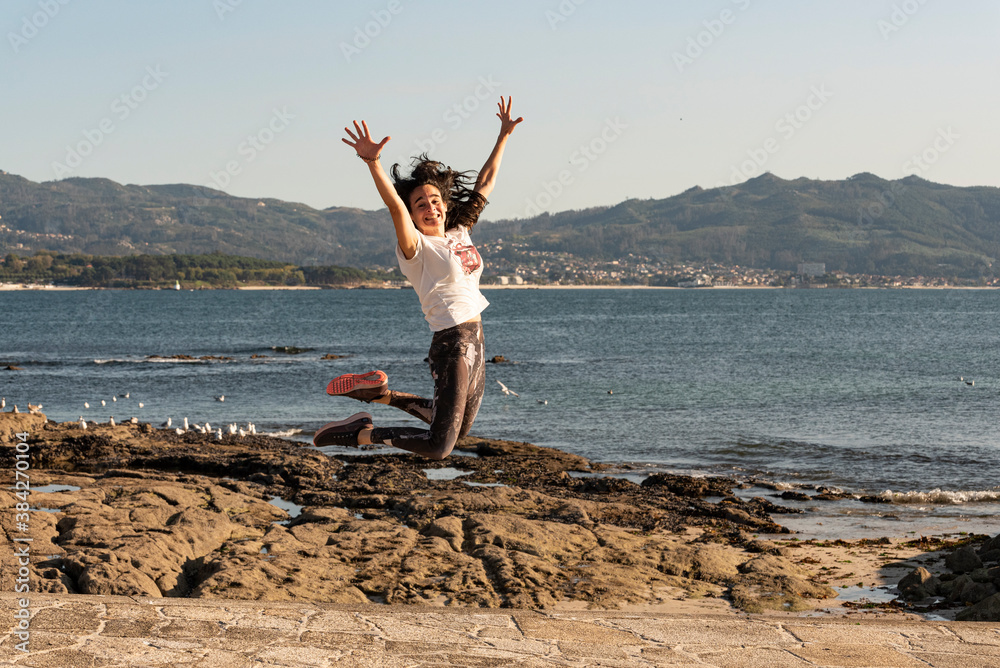 girl doing pilates exercises in front of the sea with the bay in the background girl doing pilates exercises in front of the sea with the bay in the background