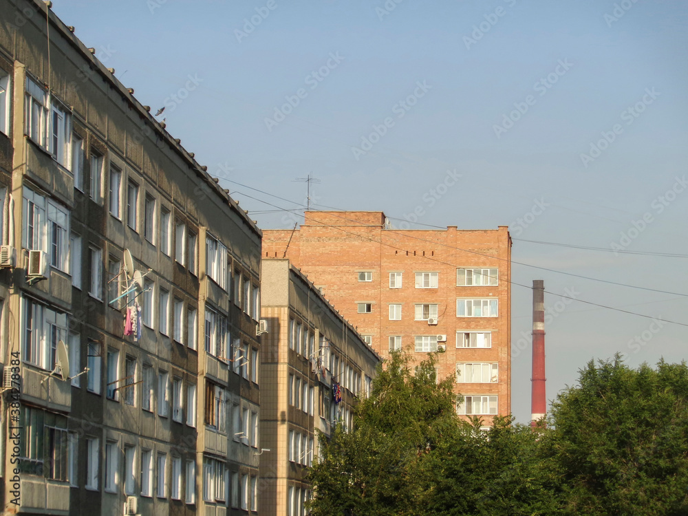 Apartment buildings. Ust-Kamenogorsk (Kazakhstan). Cityscape. Urban architectural background. Old and new residential buildings. Factory chimney