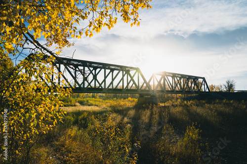 Maintenance Trains Crossing Truss Bridge in Autumn
