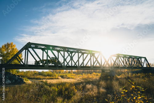 Maintenance Trains Crossing Truss Bridge in Autumn