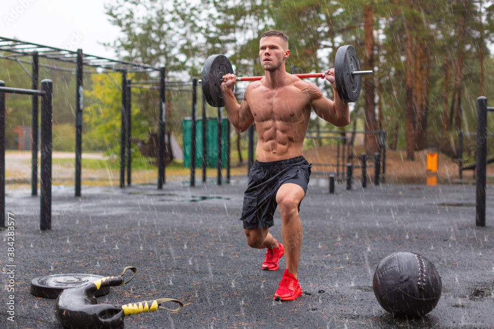 Full length photo of a man doing exercise lunges outdoors on a rainy day. Full length photo of a man doing exercise lunges outdoors on a rainy day.