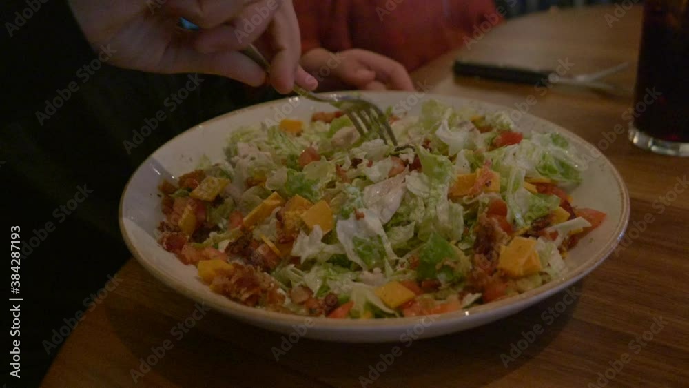 custom made wallpaper toronto digitalCaucasian male preparing to eat a Cobb salad in a dimly lit restaurant.