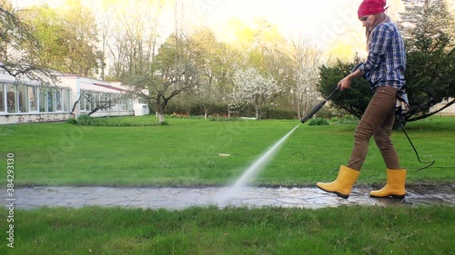 woman girl spray clean path with pressure washer in garden. 4K
