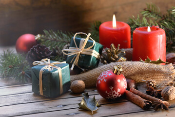 traditional christmas decoration on wooden background with candles and gifts