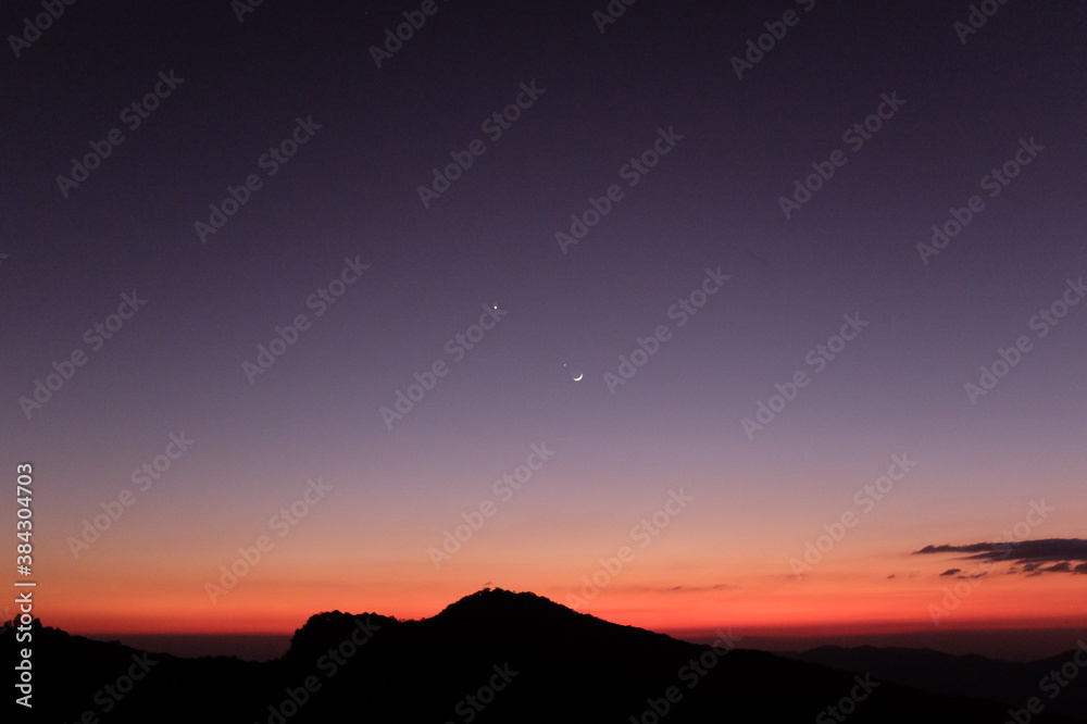 sunset over the mountains and the moon with star