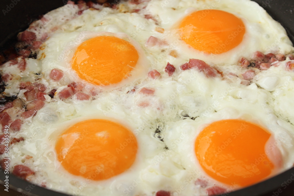 several fried eggs with bacon in the pan several fried eggs with bacon in the pan