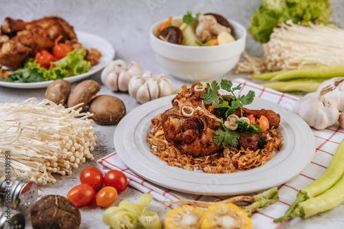 Fried chicken leg with tomato, chili, fried onion, lettuce, corn, and needle mushroom.