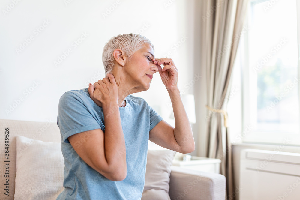 Woman suffering from stress or a headache grimacing in pain. Senior woman with migraine feeling unwell. Portrait of an attractive senior woman with a headache, feeling pain Woman suffering from stress or a headache grimacing in pain. Senior woman with migraine feeling unwell. Portrait of an attractive senior woman with a headache, feeling pain