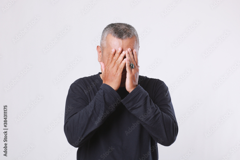 Old man playing peek a boo with hands cover face, or it can be shy expression concept too Old man playing peek a boo with hands cover face, or it can be shy expression concept too