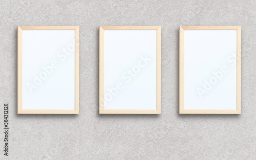 three empty rectangular frames on a gray wall.