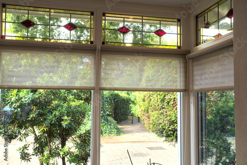 closeup of stained glass windows with red and yellow sections in a cozy beautiful home with a green view