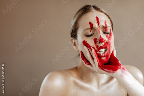 Girl is rudely taken by face. Portrait of woman with bloody mark on her face