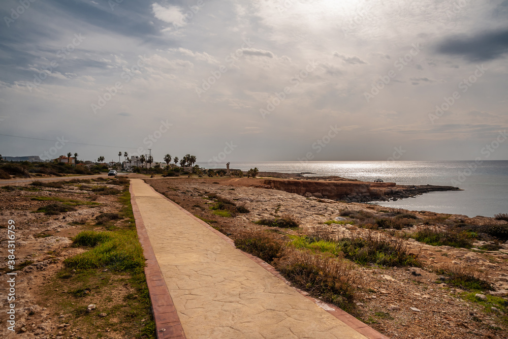Walkway on the stone seashore against the background of the sea