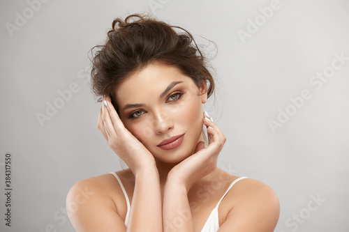 beautiful romantic woman with perfect make-up touching face