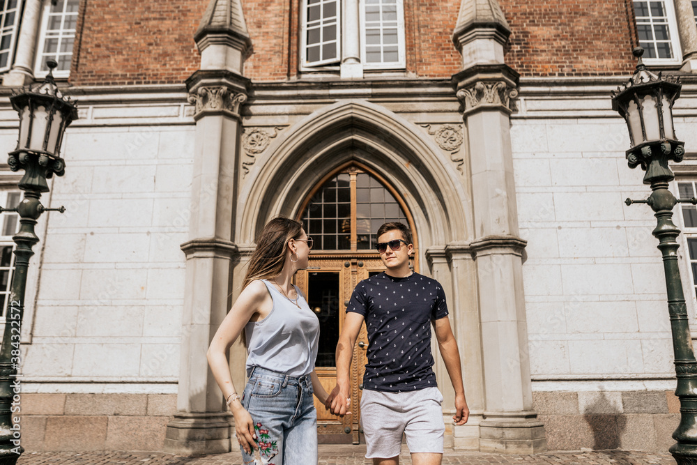 Horizontal photo of romantic couple stand hold hands and look to each other